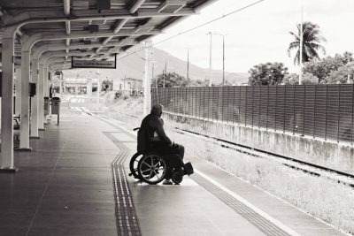 A person in a wheelchair waiting on a subway platform.