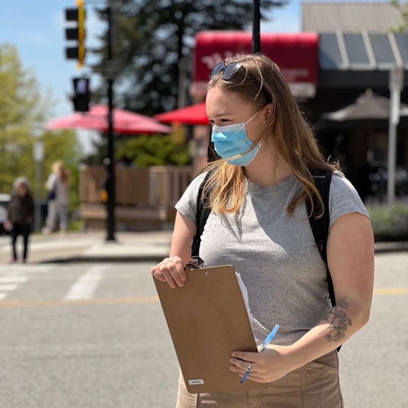 Assistant de recherche portant un masque, prenant des notes lors de l'étude d'une intersection.