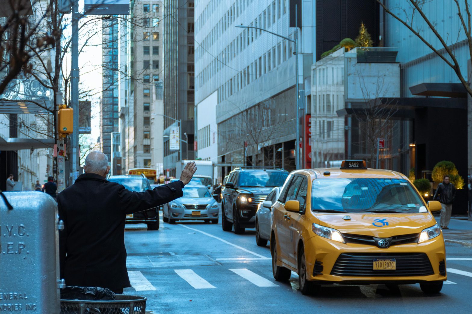 An individual hailing a yellow taxi