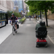 A mobility scooter user travelling on a cycle lane in downtown Vancouver.