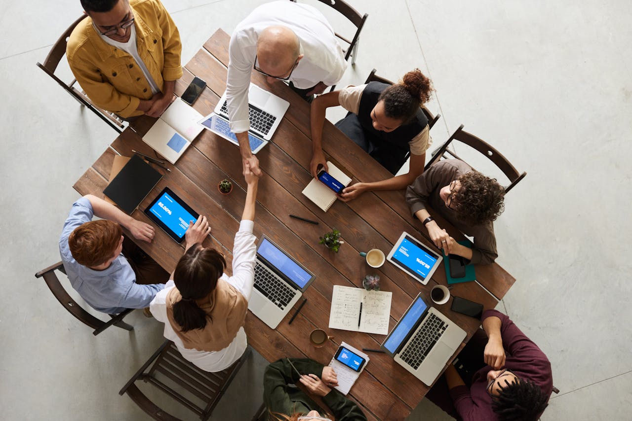 Group of people sitting around a table working on their laptops