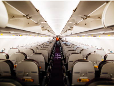 Inside an airplane looking between the aisles at the rows of seats.
